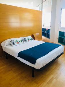 阿利坎特Estudio acogedor renfe的一间卧室配有一张大床和木制床头板