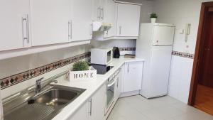马德里Residencial Caliza的白色的厨房配有水槽和冰箱
