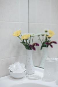 布拉格不二家酒店的浴室内一个白色花瓶,上面有鲜花