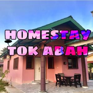 巴西富地Homestay TokAbah的房屋,上面有标志,上面写着家庭住宿的顶级代理