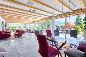 纳兹-夏韦斯Mineralienhotel Natznerhof的一间设有玻璃桌和紫色椅子的用餐室