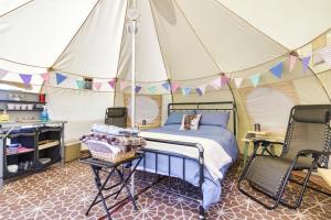 Little HautboisPitch Perfect Glamping Norfolk的帐篷内一间卧室,配有一张床