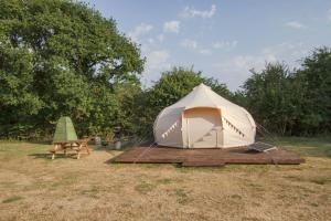 Little HautboisPitch Perfect Glamping Norfolk的田野上的帐篷和野餐桌