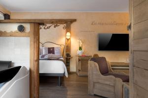 普雷圣迪迪埃贝尔维尤餐厅的一间卧室配有一张床、一台电视和一个浴缸