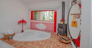 阿拉恰特Villa Taraça Alaçatı Romantik Otel的一间带大浴缸和冲浪板的浴室