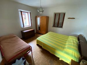莱维科特尔梅Appartamenti Nadalini的一间卧室配有一张床和一把椅子