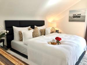 巴登-巴登RS Apartment Baden-Baden的一张白色的床,上面有一盘花