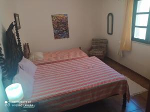 拉戈斯自然之家度假屋的一间卧室配有一张带条纹毯子的床和窗户