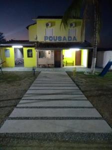 阿帕雷西达Pousada Guadalupe的夜间在建筑物前的走道