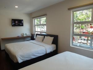 瓜埠名古屋酒店的一间卧室设有两张床和两个窗户。