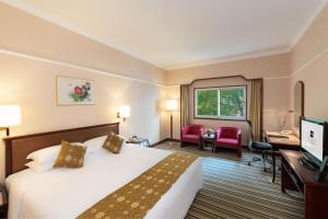北京北京丽都维景酒店的酒店客房配有一张床、一张书桌和一台电视。