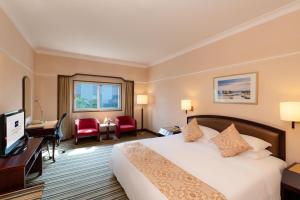 北京北京丽都维景酒店的酒店客房设有一张大床和一张书桌。