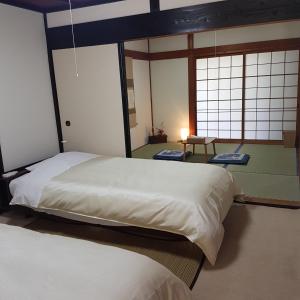 田边市旅籠まさら HATAGO MaSaRa的一间卧室设有两张床和两个窗户。