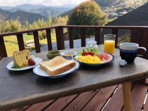 田边市旅籠まさら HATAGO MaSaRa的早餐桌,包括早餐食品和一杯橙汁