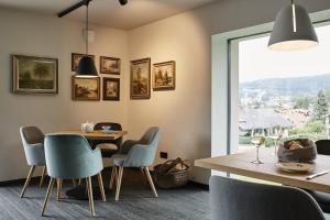 博登迈斯Winterfeld Guest House Bodenmais的一间带桌椅和窗户的用餐室