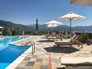 马拉松坎博斯Pleiades Samos的游泳池旁的游泳池配有椅子和遮阳伞