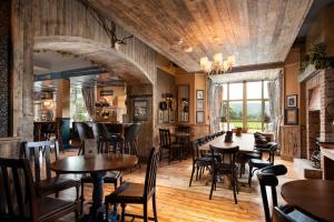 科尼斯顿The Coniston Inn - The Inn Collection Group的餐厅铺有木地板,配有桌椅