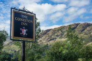 科尼斯顿The Coniston Inn - The Inn Collection Group的背景中与山脉混淆的标志