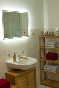 美瑟尔巴赫斯瓦兹姆Ferienwohnung FUCHSBAU im EG des Ferienhauses Falkenhöhe的浴室配有盥洗盆、镜子和毛巾