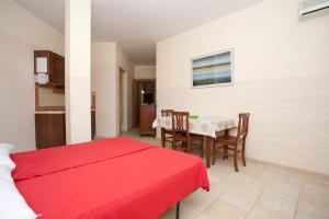 托里德欧索Residence Club Costa D'Oriente的一间卧室配有红色的床和桌椅