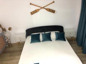 多亚马伊Casa Mediterana的一张带蓝色枕头的床和墙上的时钟