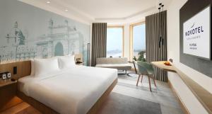 孟买孟买珠瑚海滩诺富特酒店的酒店客房设有一张大床和一张书桌。