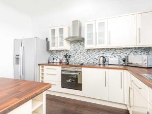 布罗迪菲利Casa Fresa - Ferry House的厨房配有白色橱柜和冰箱。