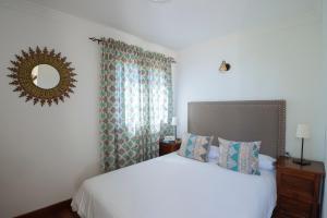 圭马尔阿瑞亚娜乡村别墅酒店的卧室配有白色的床和镜子