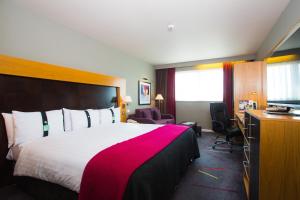西山阿伯丁西部假日酒店的酒店客房设有一张大床和一台电视。