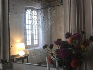 阿尔勒Le Patio d'Arles的一面带花瓶和窗户的镜子