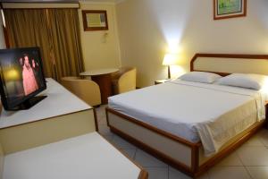贝伦Hotel Grão Para的酒店客房设有两张床和一台平面电视。