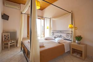 特尔斐Acropole Delphi City Hotel的一间卧室设有天蓬床和窗户。