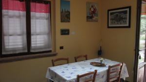 阿西西Relais"LA CAPPUCCINA" Rooms&Apartments的一间用餐室,配有一张带白色桌布的桌子