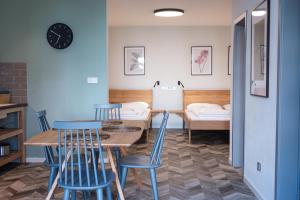 拉贝河畔皇宫镇ART Hostel & Apartments的一间带桌子和蓝色椅子的用餐室