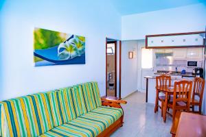 英格兰海滩Bungalows Los Almendros - Exclusive Vacation Club的带沙发的客厅和厨房