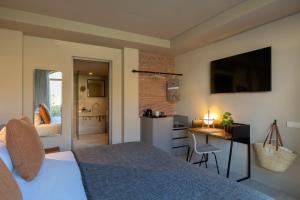 波连斯萨Can Aulí Luxury Retreat - Adults Only的一间带一张床和一张书桌的卧室和一间厨房
