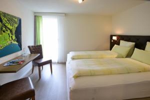 格拉鲁斯哈达南博格AG酒店的酒店客房 - 带两张床、一张桌子和一把椅子