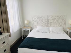 圣吉尔-克鲁瓦德维Sea View的一间卧室配有白色床、两个床头柜和窗户