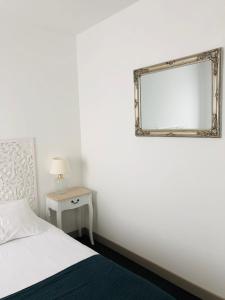 圣吉尔-克鲁瓦德维Sea View的卧室配有一张床,墙上设有镜子