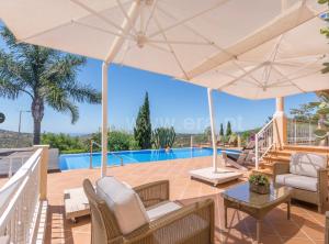 楼尔卡萨莫秋布兰科酒店的别墅 - 带游泳池和带遮阳伞的庭院