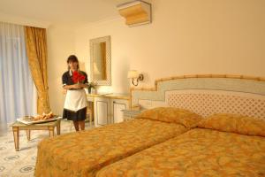 伊斯基亚伊尔莫里思科大酒店的一位妇女站在酒店带床的房间