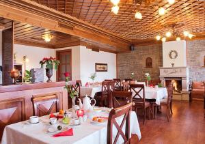 埃拉蒂扎戈里Hotel Driofillo的一间带桌椅和壁炉的用餐室