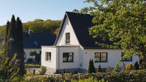 宾茨Ferienhaus Meeresrauschen的黑色屋顶的白色房子