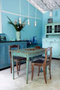 托兰克索UXUA卡萨酒店及Spa的厨房配有一张桌子和椅子,拥有蓝色的墙壁