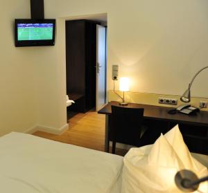 赫克斯特劳森伯格宾馆的酒店客房配有一张床、一张书桌和一台电视。