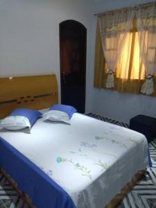 瓜鲁柳斯Pousada Guarulhos的卧室配有一张大白色的蓝色床单