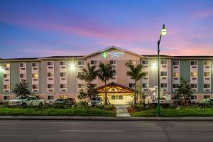 那不勒斯WoodSpring Suites Naples West的大型酒店门前设有停车场