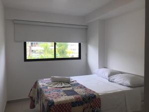 嘎林海斯港Cupe Beach Living Flat的一间卧室配有一张带毯子的床和窗户