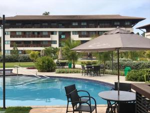 嘎林海斯港Cupe Beach Living Flat的酒店游泳池配有桌椅和遮阳伞