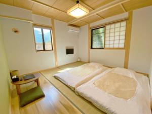 下吕市Toraya的一间卧室配有一张床、一张桌子和两个窗户